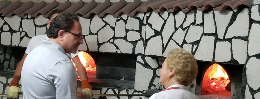 Tony in front of pizza oven in Italy